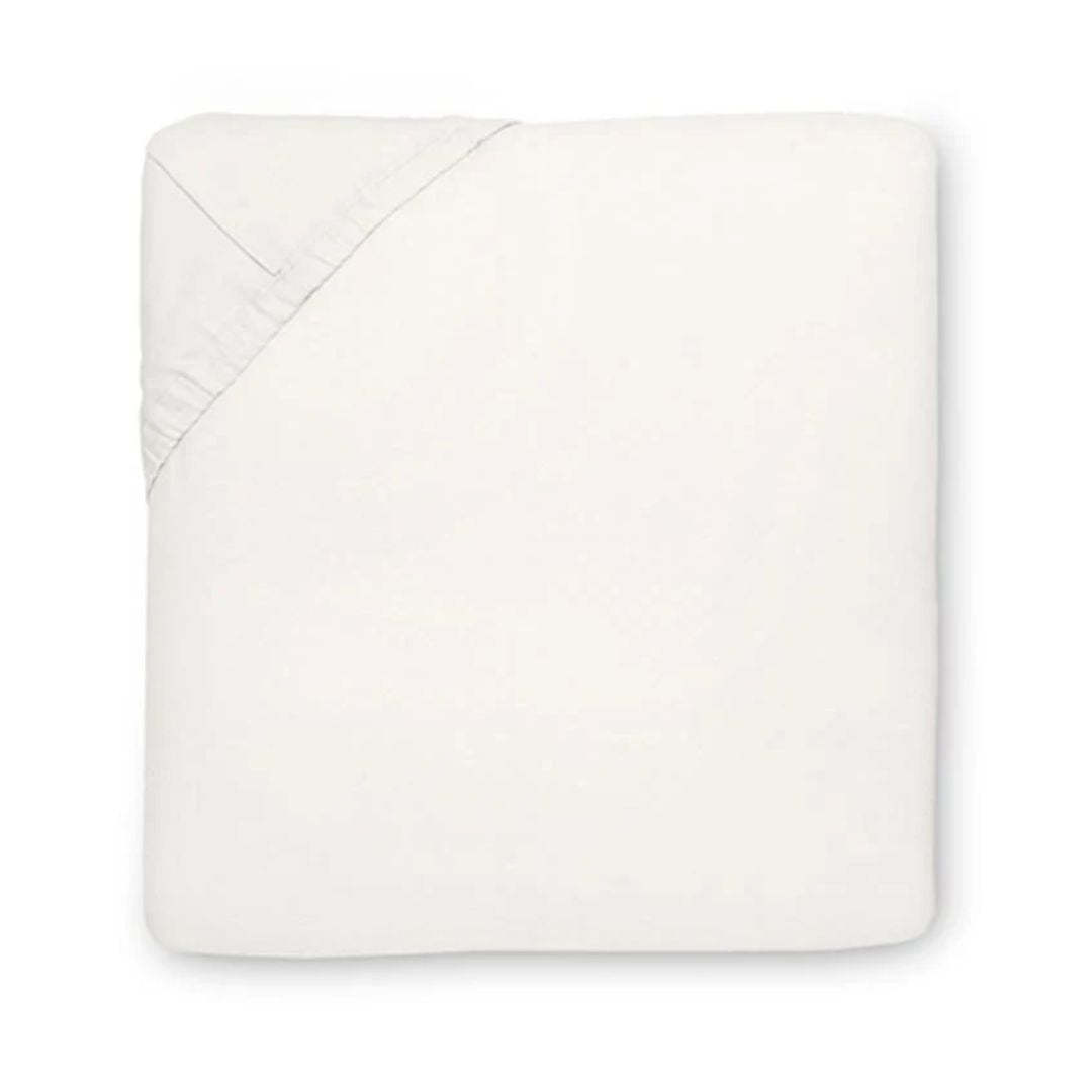 A neatly folded off-white fitted sheet of Italian spun sateen, with one elastic corner, set against a white background.
