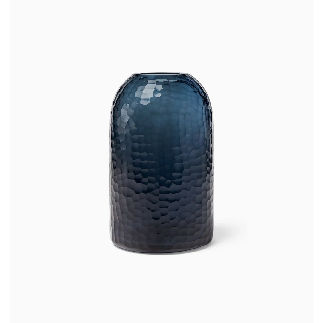Tall, cylindrical Sferra Oculus vase in dark blue with a textured, hammered surface, set on a plain white background.