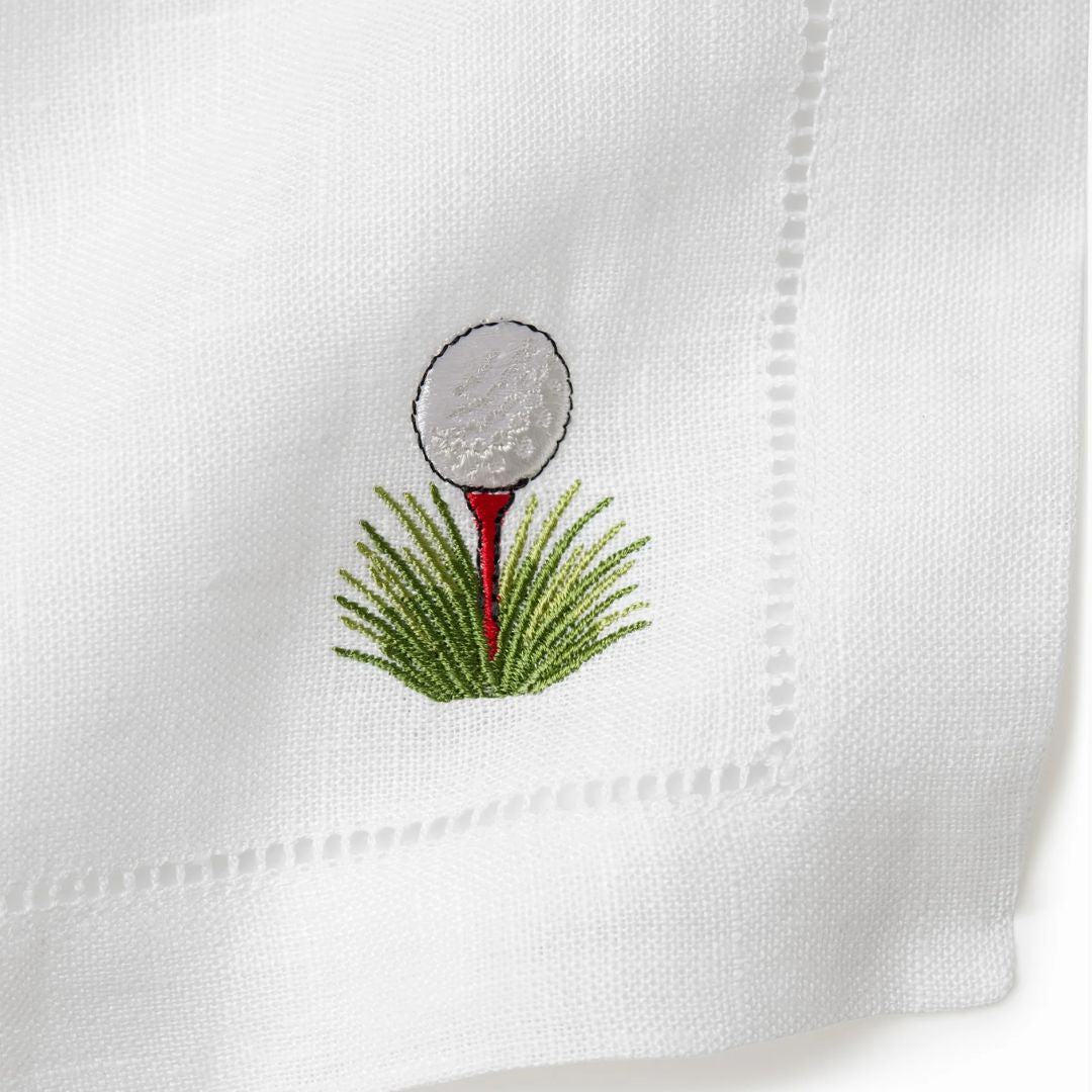 Embroidered golf ball and tee on a white cocktail napkin