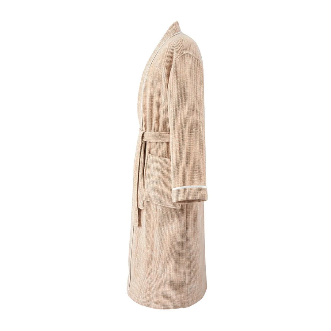 Side view of a tan, lightweight cotton honeycomb bathrobe with a tie waist and white trim on the sleeves.
