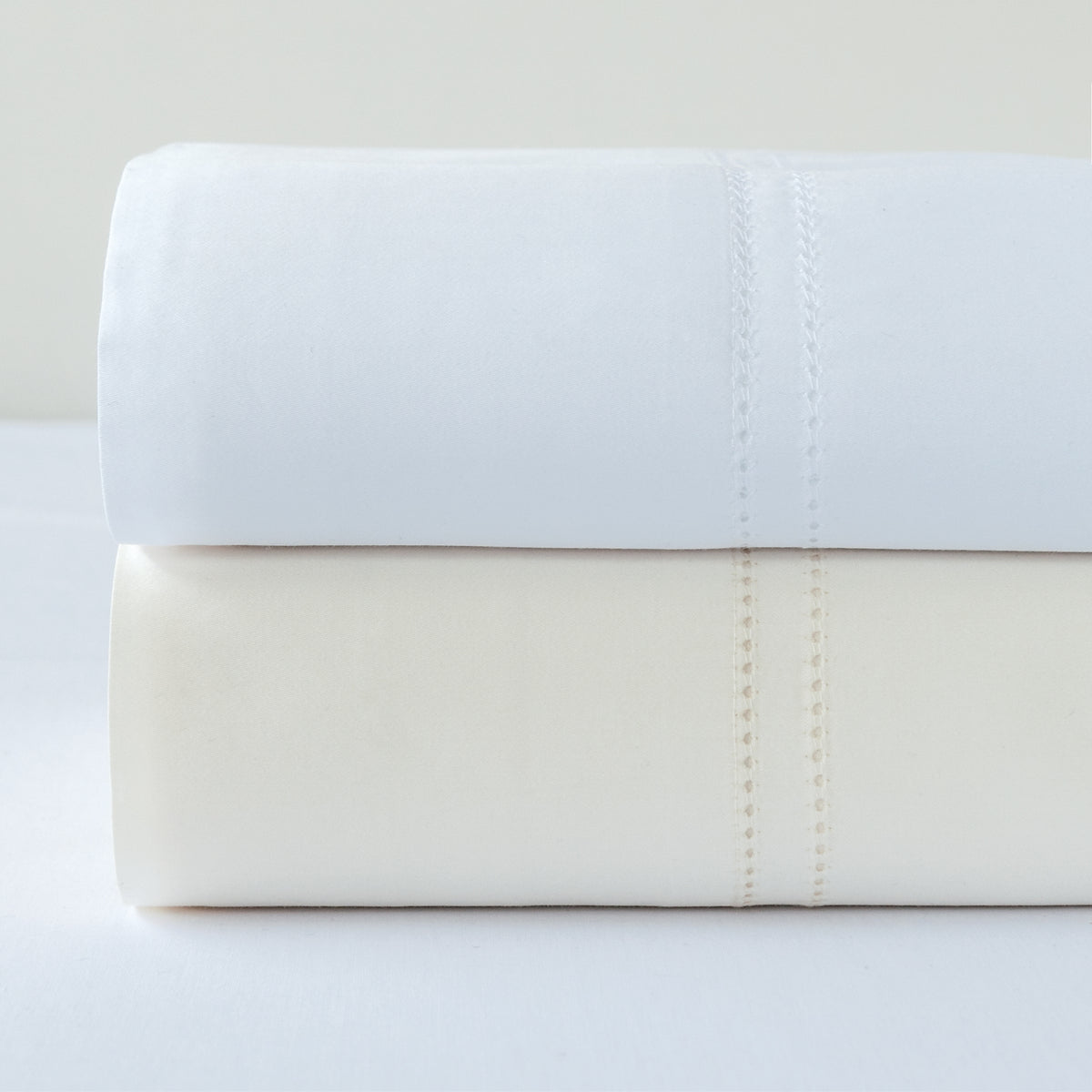 Stack of BOVI Simply Sateen Bedding Sheets Ivory and White