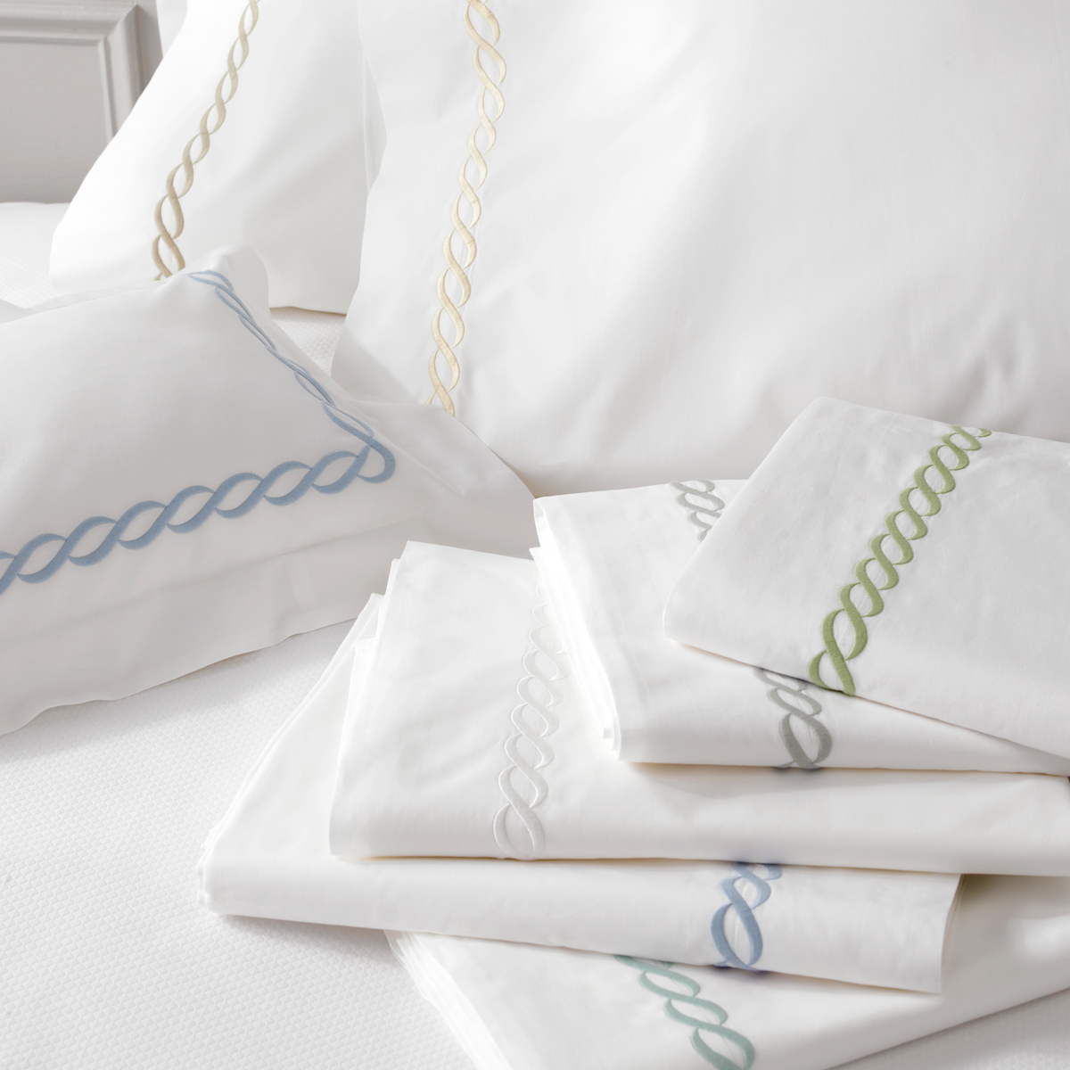 Stack of Matouk Classic Chain Bedding Flat Sheets and Shams in All Colors