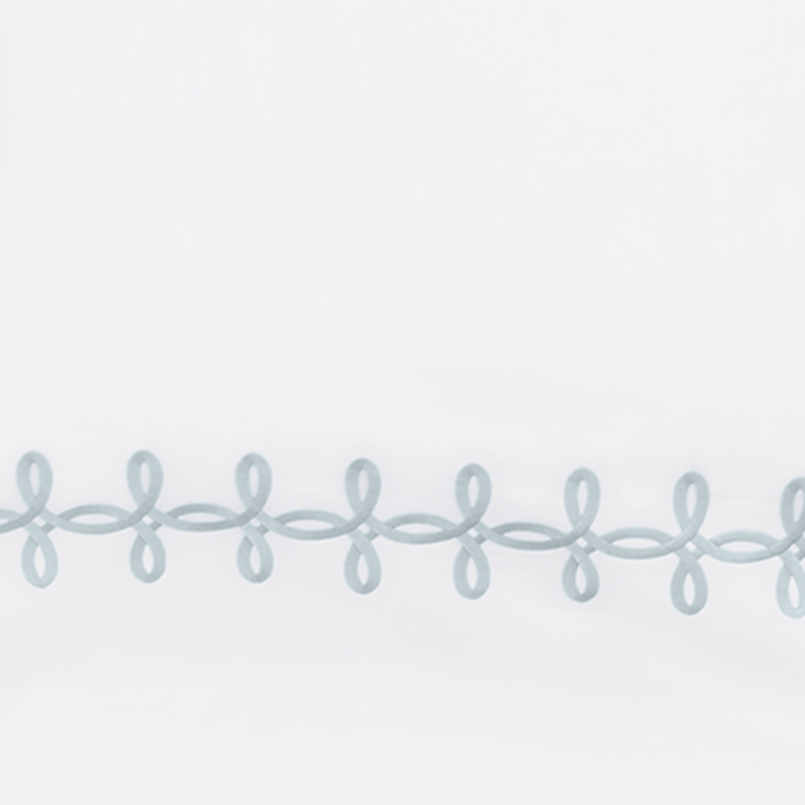 Full Lifestyle Image of Matouk Gordian Knot Bedding with Swatch of Blue