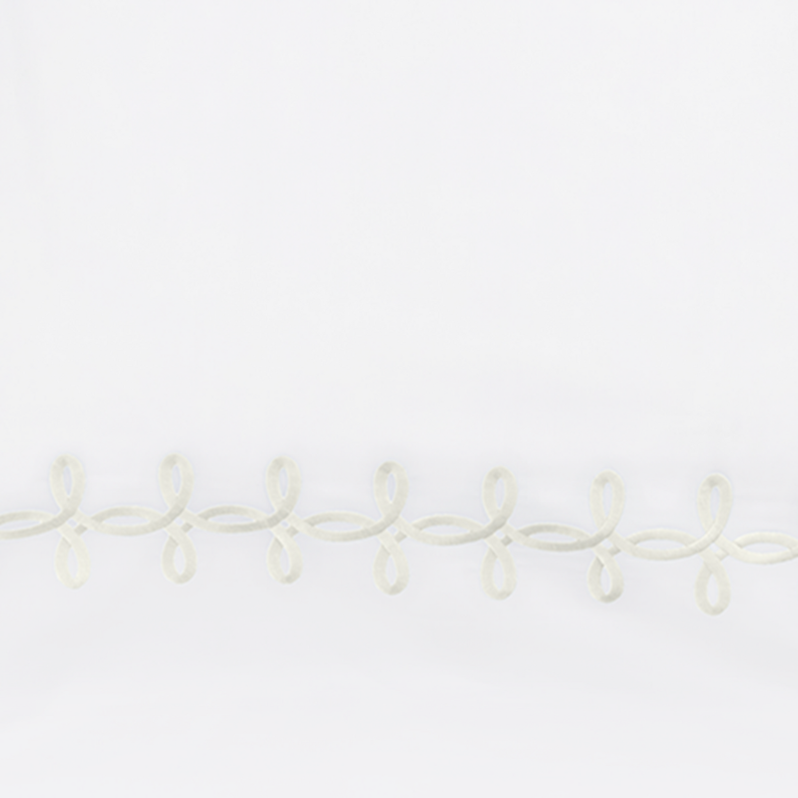 Full Lifestyle Image of Matouk Gordian Knot Bedding with Swatch of Cream