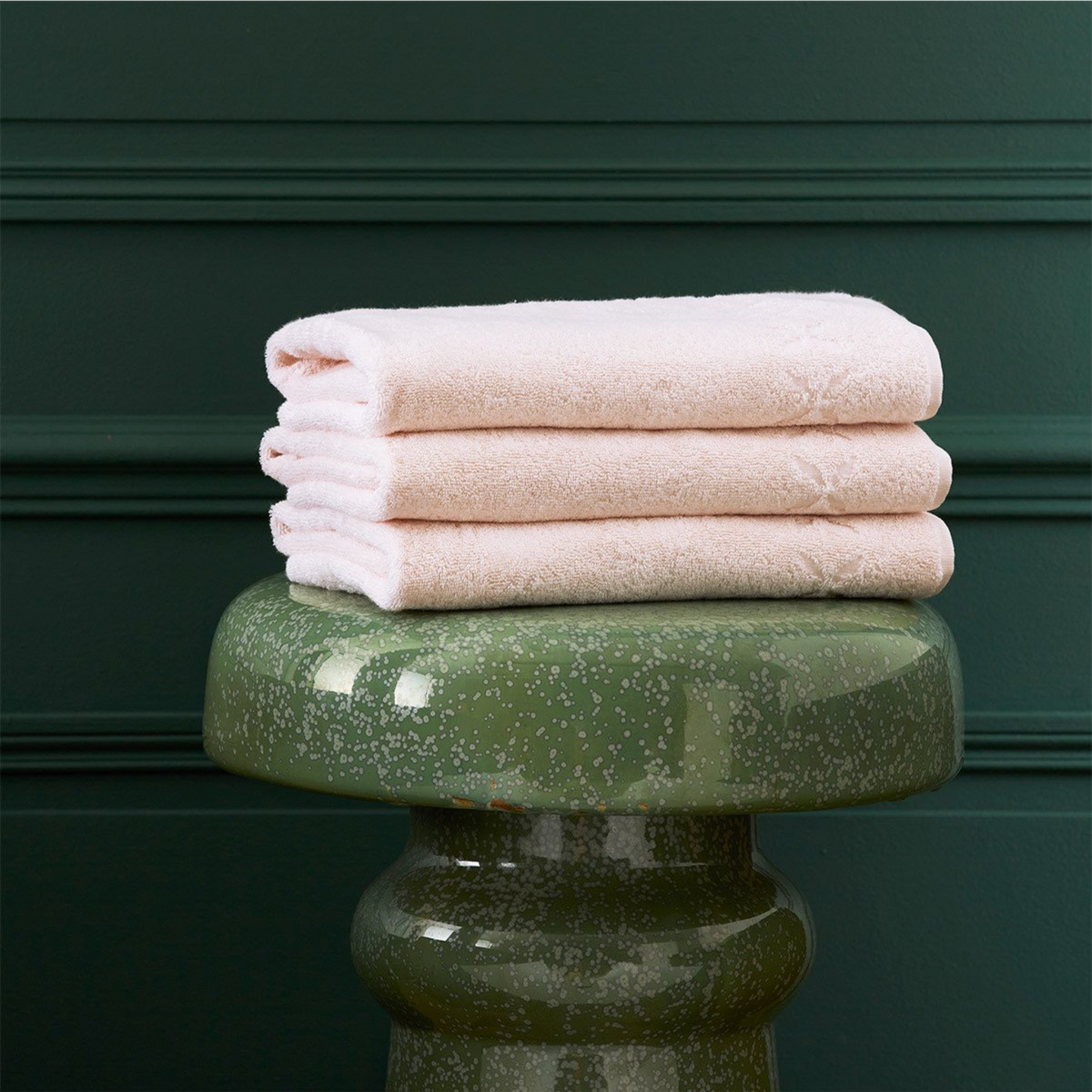 Lifestyle Image of Stack of Folded Yves Delorme Nature Bath Linens in Poudre Color