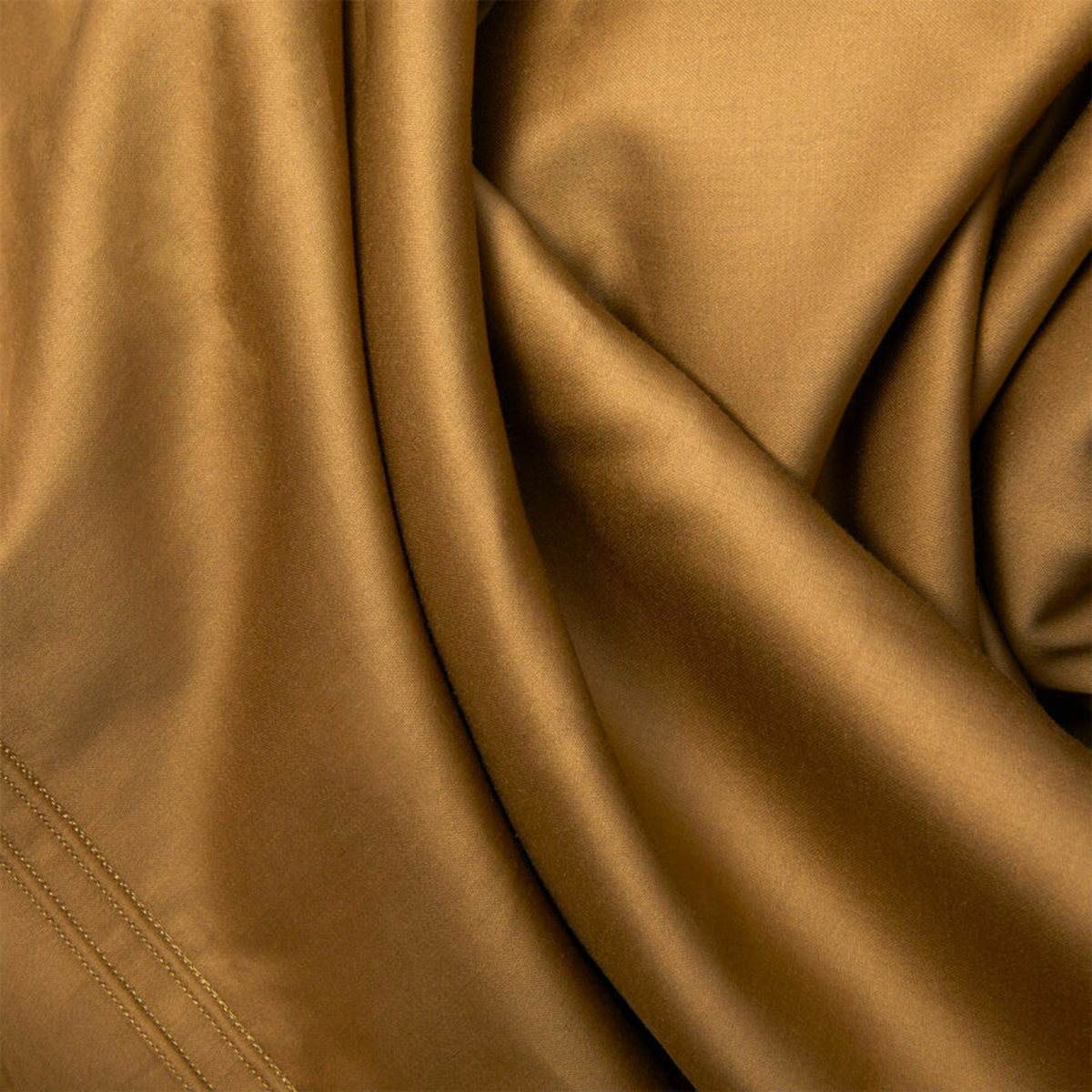 Closeup View of Sheet of Yves Delorme Triomphe Bedding in Bronze Color